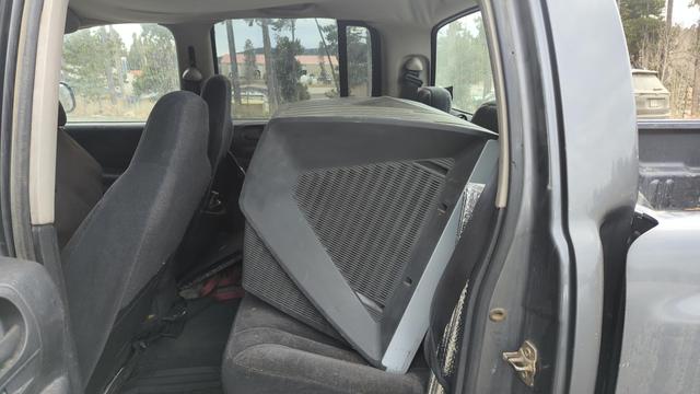 A Sony CRT television, resting in the back seat of a grey pickup truck. The set is a little dirty as it was just rescued from the dump.