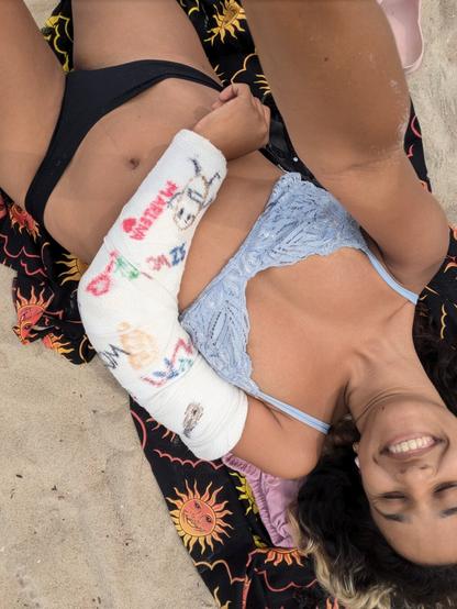 A woman on the beach with an arm cast