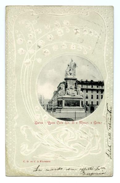 The image shows an old postcard featuring a detailed black and white photograph of the Monument to Victor Emmanuel II in Turin, Italy. The statue is situated on top of a pedestal adorned with smaller figures or statues at its base. Behind it stands a row of classical European buildings suggesting this monument is located near a historic part of town.

The card has an ornate border design that includes floral patterns and swirls which adds to the antique aesthetic typical for postcards from past centuries. The text on the image indicates "Torino - Piazza Carlo Emanuele II e Monum. à Cavouer," suggesting this may be a caption or dedication related to Turin, Italy's Monument to Charles Emmanuel II.

At the bottom of the card is handwritten calligraphy that appears to read: "C.G et C'à Florence" and another line with cursive script which seems more difficult to decipher but indicates signatures. This handwriting likely belongs to someone who signed off on this particular postcard or perhaps added a personal message before sending it out.

The overall condition of the card looks worn, suggesting its age and possibly frequent handling over time. The wear is particularly noticeable at the edges where they are frayed and discolored, indicating that this item has been used multiple times for correspondence in the past.