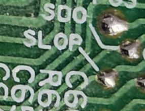 a solder via on a PCB labeled "SLOP"
