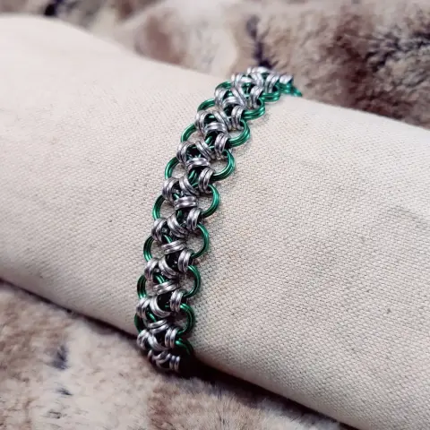Bracelet en maille qui fait penser à une bande de dentelle de métal.