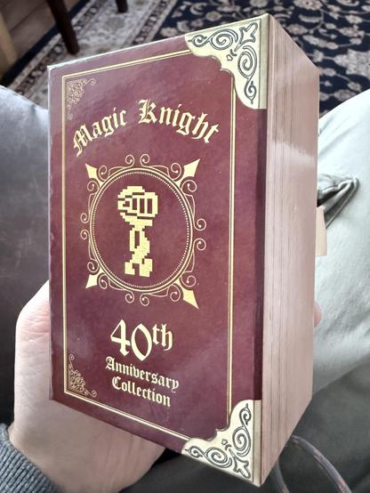 A brown box set made to look like a thick leather and gold bound book containing the 4 game cassettes