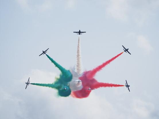 Eight Italian Frecce Tricolori aircraft performing a break maneuver