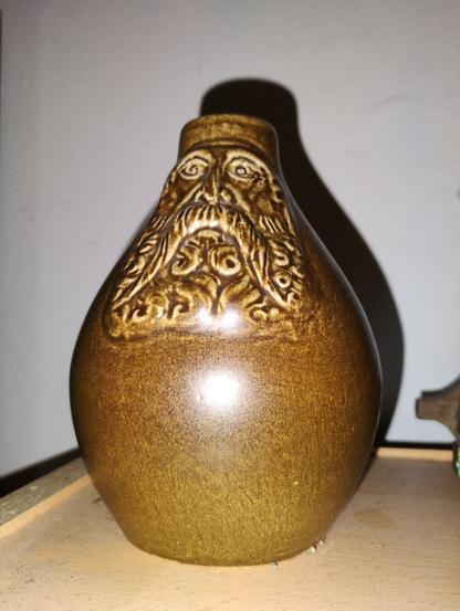 A round salt-glazed jug with a bearded face.