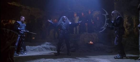 Paris in a ring with a Klingon holding bat’leths