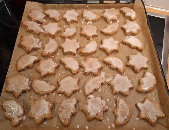 cinnamon stars and moons on a oven tray glazed with icing