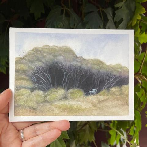 painting of a copse of trees and a white unicorn making a break for it into the light, galloping out across the field.