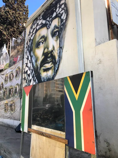 Mur avec un graph portrait de Yasser Arafat et des drapeaux palestinien et sud-africain