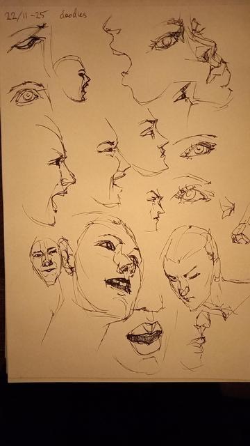 Sketchbook page with ink drawings of faces.