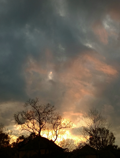 Yellow, orange & pink sunset with gray clouds.