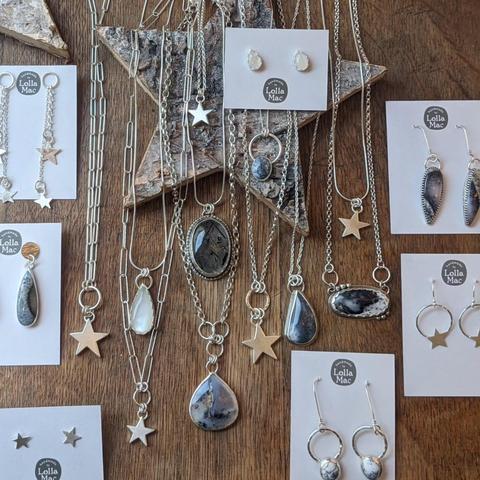 A display of the latest winter mini-collection from LollaMac, featuring white/grey stones with black or sparkly inclusions, and other pieces featuring silver stars