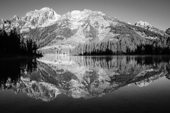 The Tetons reflected in the waters of String Lake. From left to right, Symmetry Spire, Mount Saint John, and Rockchuck Peak.