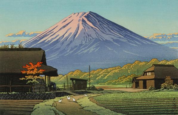 An early morning view looking toward Mount Fuji, from a rural farm. In the foreground, on a path curving between two cultivated fields, chickens scratch and peck at the ground; just beyond, a female figure is occupied with some task just outside the front door of the traditional thatched-roof farmhouse. Further on, a line of trees underscores the wide base of Mount Fuji; the rising sun tints the mountain's snowcap a rosy colour, and turns the few puffy clouds flanking the slopes a warm gold.