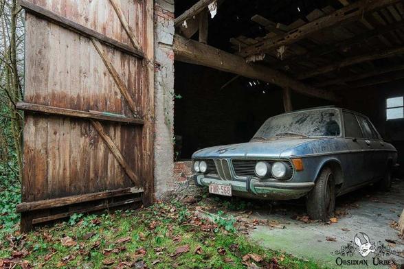 old dusty blue BMW in a barn