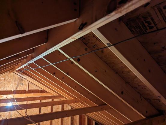 View along the length of a 10m half wave dipole antenna. The antenna is running along the framing under the peak of a roof in an attic.
