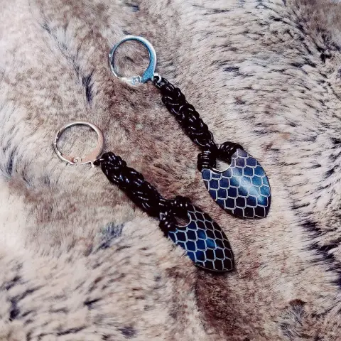 Mêmes boucles d'oreilles, mais cette fois les anneaux et les écailles sont noires. De plus, le motif représente des écailles à la place des plumes.