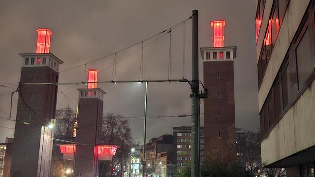 Foto der Schwanentorbrücke in Duisburg: Die Glasaufsätze auf den Brückentürmen sowie die Kanzel zur Steuerung der Brücke sind orange beleuchtet.