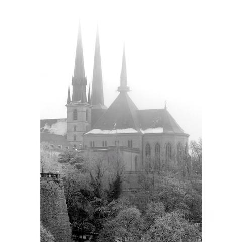 Black and white picture of the cathedral of Luxembourg under a snsnowy winter weather.