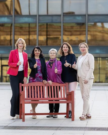 Landtagspräsidentin Muhterem Aras steht mit Abgeordneten hinter roter Bank vor dem Landtagsgebäude