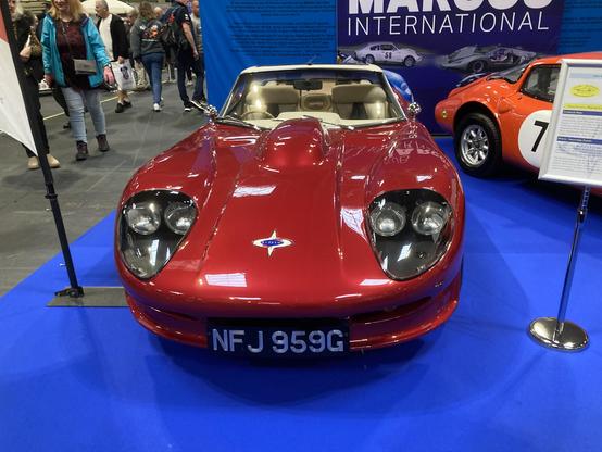 Red metallic Marcos V6 GT with white roof, frontal view