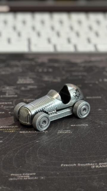 Eine kleine, silberne Spielzeugauto auf einer Weltkarte.