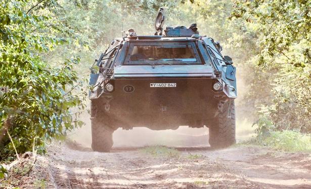 Geländewagen fährt auf einer staubigen Landstraße durch eine grüne Landschaft. Erkennbare Schrift: '17'.