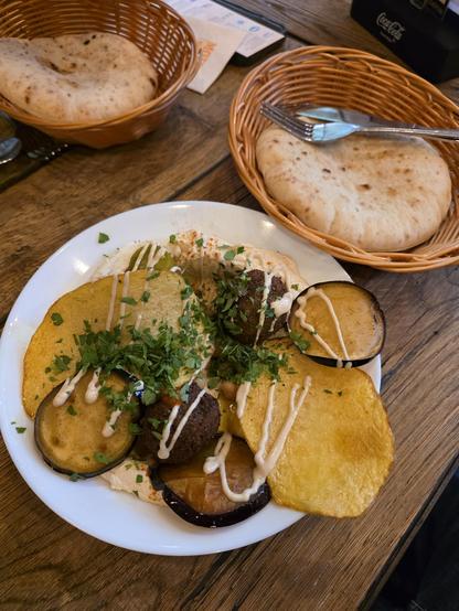 falafal with egg plants and hummus with pita bread on the side