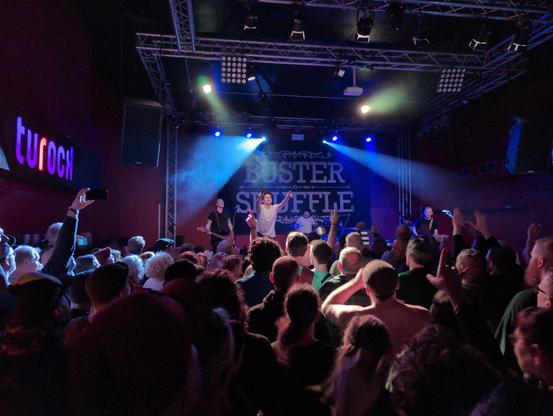 Picture from the crowd showing the band Buster Shuffle on stage