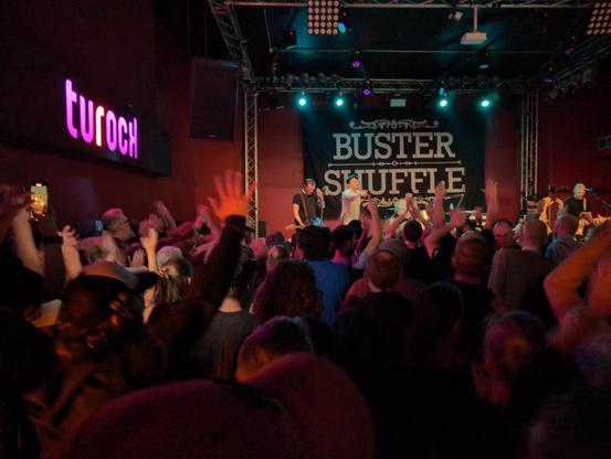 Picture from the crowd showing the band Buster Shuffle on stage