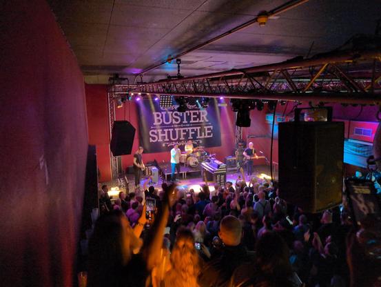 Picture from the crowd showing the band Buster Shuffle on stage
