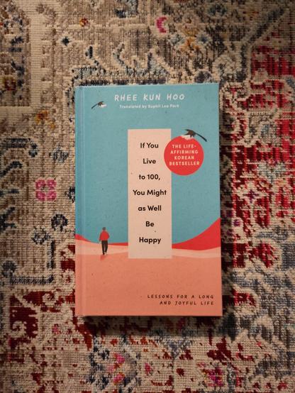 Kuvassa kirjan kansi, jossa piirretyssä maisemassa henkilö kävelee poispäin. Maa on punainen, sinisellä taivaalla lentää kaksi lintua.