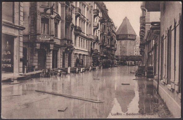 Printed sepia postcard showing a view of the flooding on the Seidenhofstrasse at Luzern or Lucerne in Switzerland in mid-June 1910.

Published by Caspar Hirsbrunner, Luzern, not numbered, printed by Art. Institut Orell Füssli, Zürich, 1910.

Postally used on 6 July 1910, stamp with cancellation removed, and sent to A.E. Lee Esq, Hooley Villa, Heywood, Lancashire, England.

Very good condition, with very slight corner bumps.