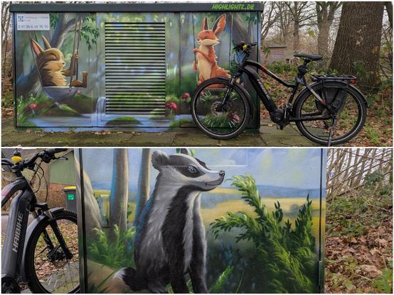 Bildkollege:
Oben: bemalter Stromkasten mit 2 Hasen , einer sitzt auf einer Schaukel, der andere sitzt auf einer Schaukel in einer idyllischen Landschaft am Bach. Daneben steht ein schwarzes Haibike Trekking Fahrrad 
Unten: Ein bemalter Stromkasten mit einem Dachs der neugierig nach rechts schaut. Links ist das Vorderrad eines Fahrrads zu sehen.