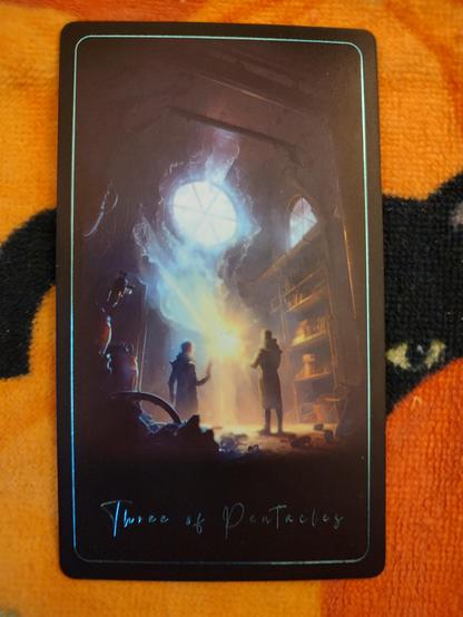 Card from the Tarot of the Sacred Kingdoms deck. 
Three of Pentacles.
Two persons in an old chamber, like a library. There is a floating bright orb in front of them, and a large glass round window above them.