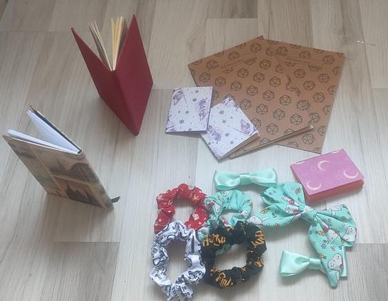 4 Scrunchied different types of fabric, 3 mini notebooks, 2 hardcover notebooks, and 2 dungeons and dragons character sheets.