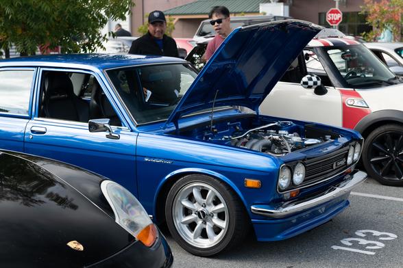 A classic Japanese sedan in bright metallic blue, with its hood open.
