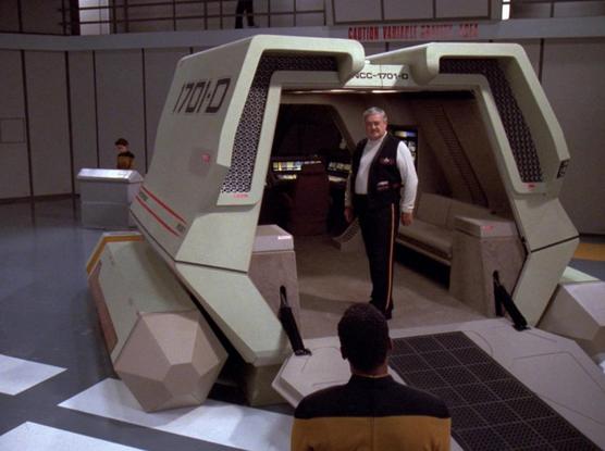 A still from Star Trek TNG of Scotty standing inside a shuttle craft. There is no room for a toilet, at least not a private one.