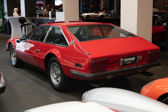 Rear three quarter view of a red vintage Italian fastback coupe.