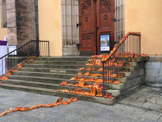 Viele orange Schuhe auf der Treppe zur Marienkirche in Hof