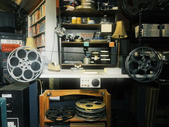Multiple photos of the Hollywood Theatre archive display movie posters, film reels, a splicing table, and a giant sign that reads, "BEN HUR."