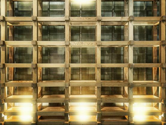 Criss-crossed wooden support beams fill the frame, lit from below by a recessed light source.