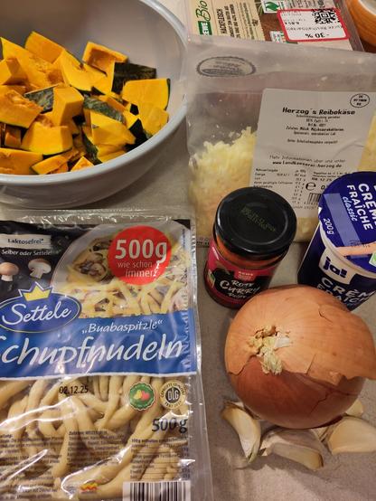 Die Zutaten für den Auflauf, wobei der Kürbis bereits in Stücke geschnitten wurde.