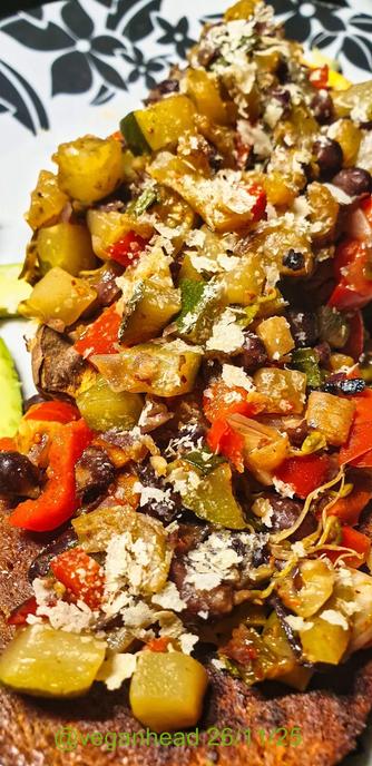 A plate of Goodstore 'Vegan Tender Steak',  Baked Sweet Potato topped with Stir Fried Vegetables, served with Fresh Avocado & Tomato. Topped w/ Yeast Flakes.