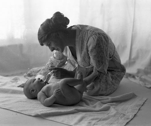 A woman looking at a baby.