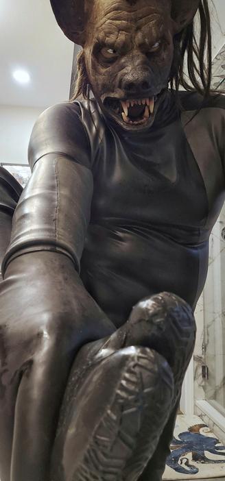 Hyena in full neoprene, latex gloves, and latex+neoprene tabi boots stares and looms over you, holding one of his boots.