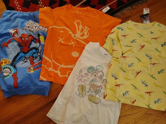 An Amazing Spiderman hoodie (with tags) an orange Kaws x Uniqlo tee, a Japanese Mickey Mouse tee, and a yellow dinosaur tshirt (new with tags).