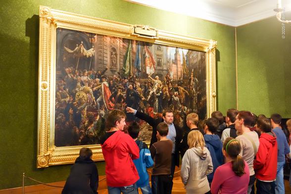 Famous painting by Jan Matejko of the declaration of the second-oldest constitution in the world, 3 May 1791, Polish-Lithuanian Commonwealth, as being described (with actions) to a school group.  The painting is housed in the castle seen in the picture.