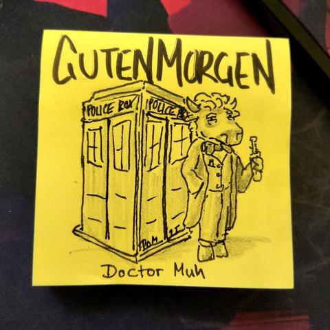 Auf einer gelben Haftnotiz steht "guten morgen"
Darunter ist eine Polizei box, die Tarnung der TARDIS, abgebildet. Davor steht eine Kuh mit Anzug, Trenchcoat, Fliege und Schallschraubenzieher.
Es handelt sich um Doctor Muh.
