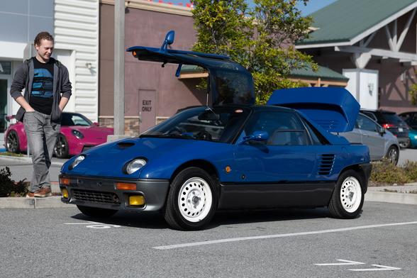 A tiny blue car with gullwing doors.