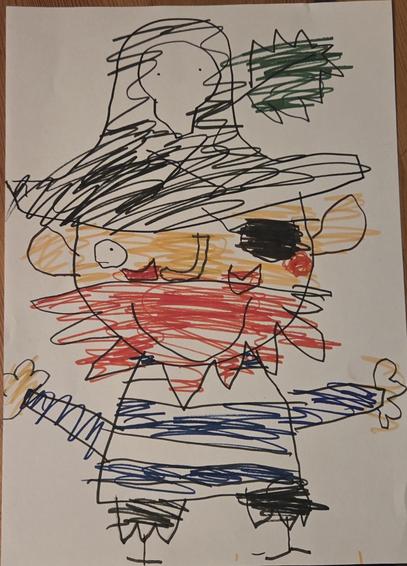 A child's drawing of a pirate. He is wearing a blue and white striped top and has a big yellow-orange  head with a bright red beard . He is wearing a black hat with a skull on it and a green fuzzy decoration at the top. He is wearing a black eye patch over one eye and has two stick legs poking out from ragged black shorts. He's smiling widely.